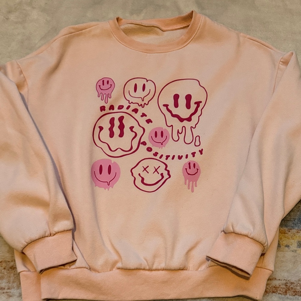 (147)Radiate Positivity Smiley Face Graphic Sweatshirt Cream Pink Pullover